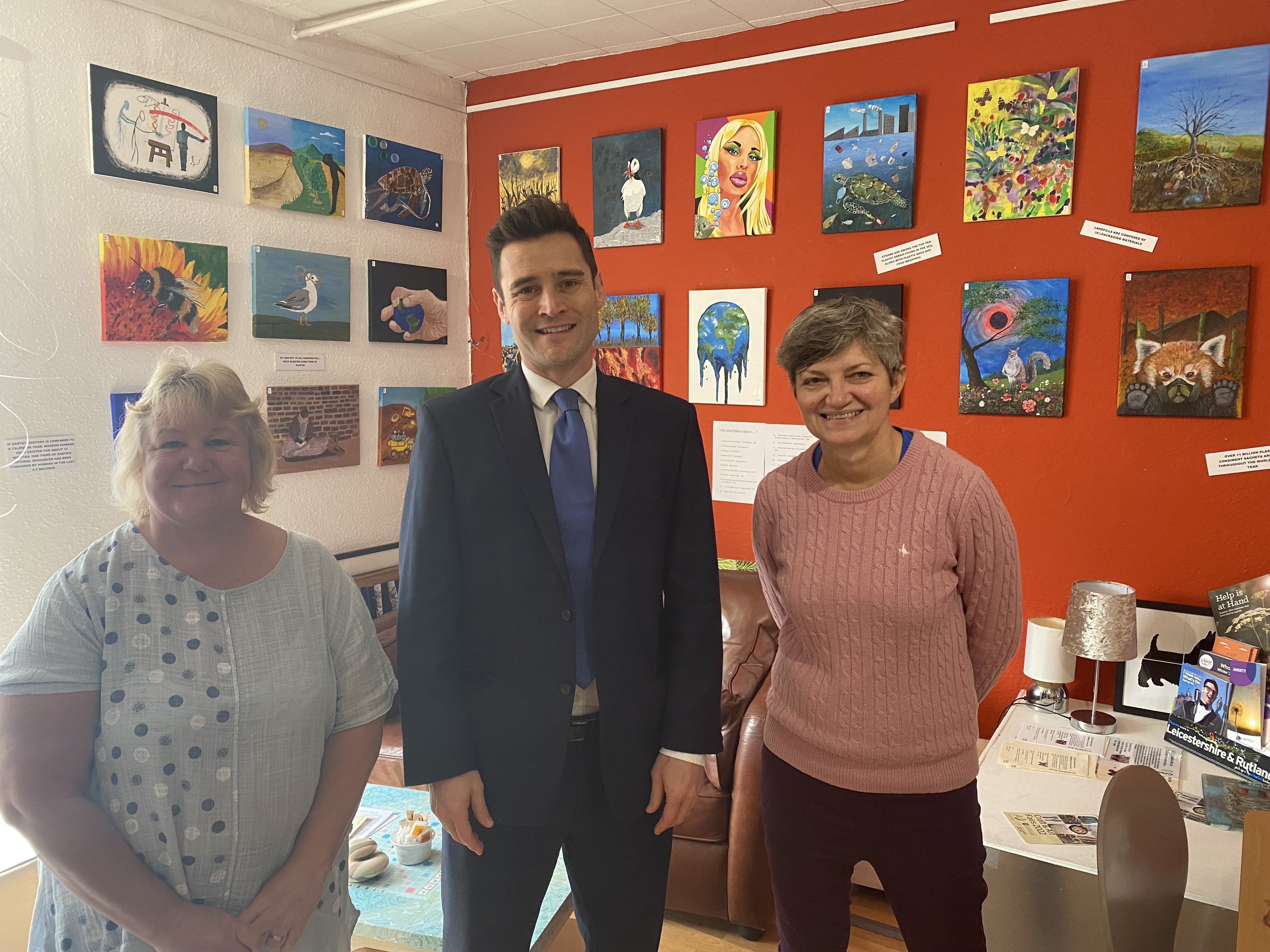 (L-R) Linda Flower, Dr Luke Evans MP and Rose Wilkinson in front of some of the paintings